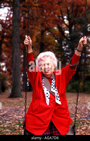 Im Ruhestand Senior Frau genießen Herbstfarben auf Schaukel Stockfoto