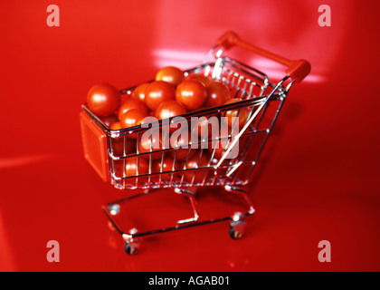 Mini-Tomaten auf einem reflektierenden roten Hintergrund voller Mini caddie Stockfoto