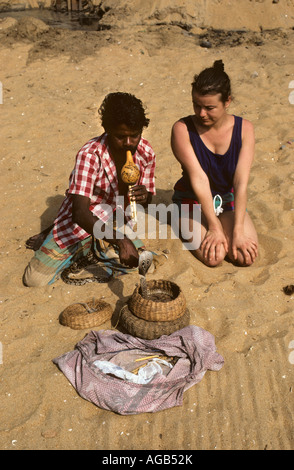 Sri Lanka Negombo, Schlangenbeschwörer, während Touristen sitzen auf Sand durchführen Stockfoto