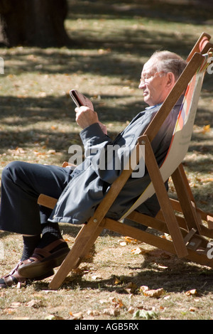 Ein Mann auf einem Liegestuhl im Green Park in London Stockfoto