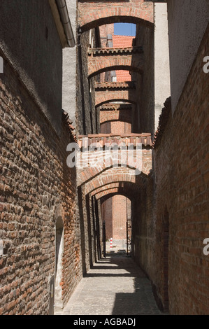 Enge historische Gasse mit Backsteinbögen im Stadtzentrum von Elblag (Elbing), Polen. Traditionelle mittelalterliche Architektur in der Altstadt. Stockfoto