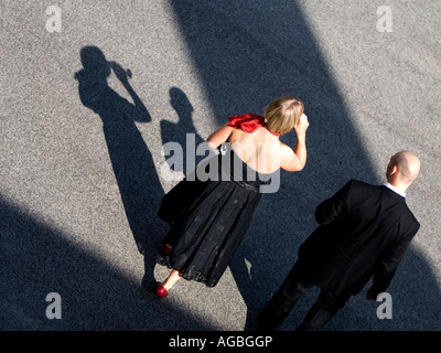 Junge Dame im schwarzen Kleid und roten Schal trinken Champagner mit einem schwarzen Schatten und sillouette Stockfoto