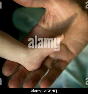 Vater hielt seinen Fuß Baby s Stockfoto