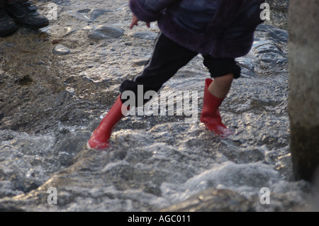 Junges Mädchen spielen im Wasser Ogmore von Meer Wales UK Stockfoto