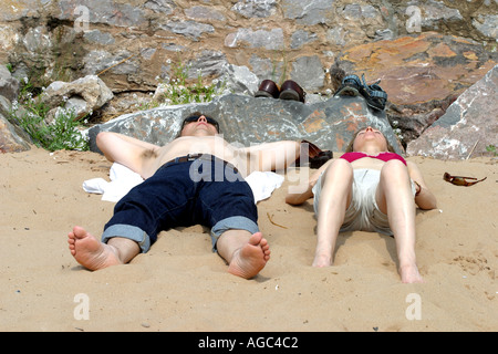 Paar, Sonnenbaden am Strand von Exmouth Stockfoto