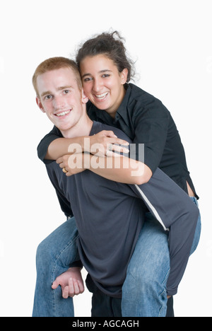 Porträt einer jungen Frau Reiten Huckepack auf einem jungen Mann Stockfoto