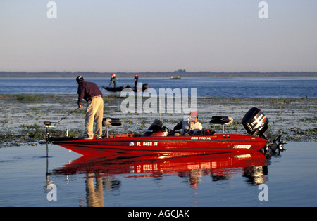 Angler in rote Bass Boot kurz nach Sonnenaufgang Stockfoto