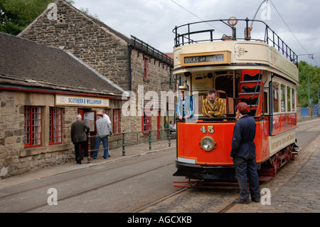 Eine offene überstieg High St Straßenbahn-Haltestellen auf den gepflasterten Straßen in Crich Tramway Museum und ein Fußgänger auf der Strecke im Gespräch mit der straßenbahnfahrer. Stockfoto