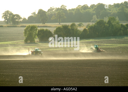 Landwirtschaftlich genutzte Landschaftstraktoren, die bei starkem Wind auf trockenem Feld arbeiteten und eine staubhaltige Bodenerosion in der Nähe von Ingatestone Essex England verursachten Stockfoto