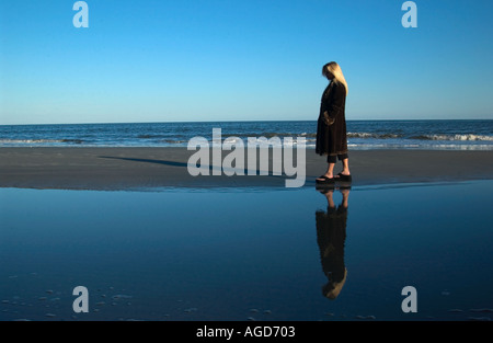 Kaukasische Mädchen in Mantel geht bei Hunting Island Beach SC im Herbst USA Stockfoto