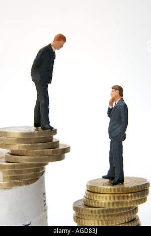 Business / banking / lending / finance / take over / investment concept - two figures standing on piles of coins Stockfoto