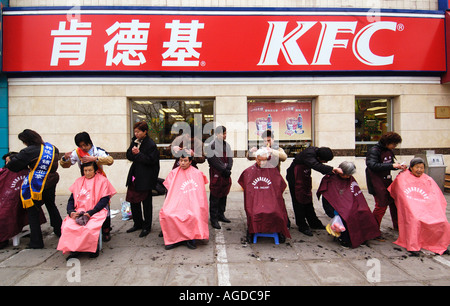 Outdoor-Friseure schneiden Haare auf Straße vor KFC Restaurant in Beijing China 2004 Stockfoto