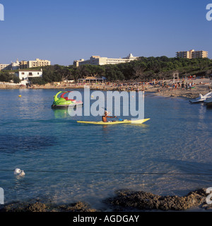 Szene am Cala Agulla - Kanu + moderne Fun Boot im Meer aus idyllischen Sandbucht in der Nähe von Cala Ratjada, Nord-Ost-Mallorca, Spanien. Stockfoto