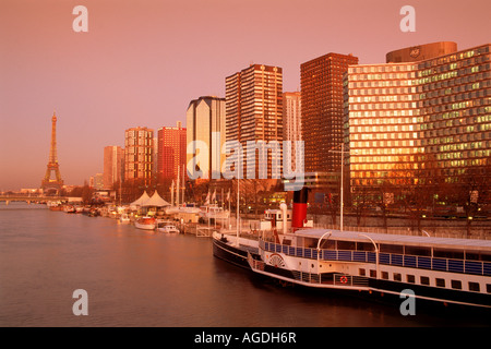 Eiffel-Turm am Ende der Front De Seine mit Ausflugsschiff auf Fluss Seine in Paris bei Sonnenuntergang Stockfoto
