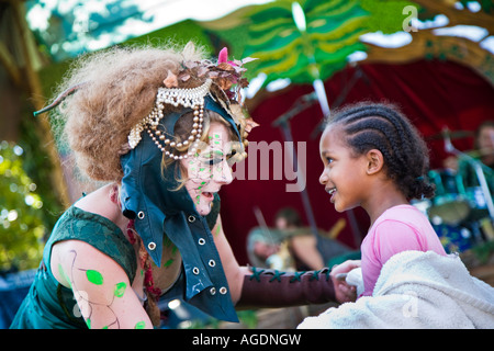 Eine Dame eintreten für einen umweltfreundlichen Lebensstil und gekleidet wie eine Waldnymphe, Tänze mit einem hübschen jungen Mädchen an der Thames Festival Stockfoto