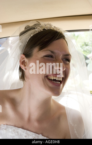 Lachende Braut im Hochzeitsauto Stockfoto