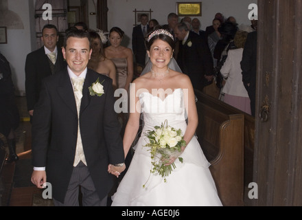 In Hand, glücklich Frischvermählten Spaziergang hinauf Gang des englischen Pfarrkirche. Stockfoto