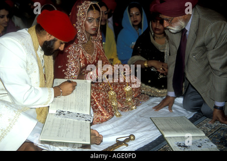 Sikh Brautpaar Unterzeichnung Personenstandsregister nach der Zeremonie in der gurdwara Stockfoto