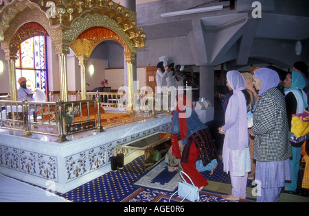 Sikh-Frauen zollen, Guru Granth Sahib in Southall Gurdwara. Outer London Stockfoto