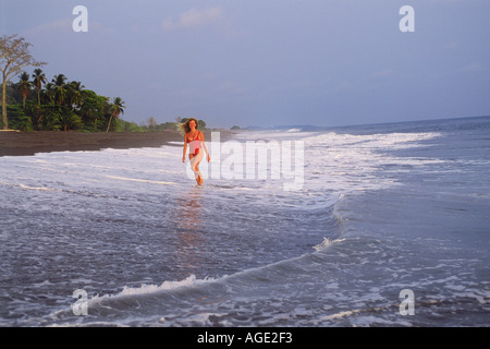 Frau am schwarzen Lavasand Strand von Playa Hermosa in Costa Rica Stockfoto