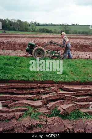 Ein Bauer mit einem Oldtimer Benzin angetrieben Hand Pflug in einem Feld auf dem Lande Worcestershire England UK Stockfoto
