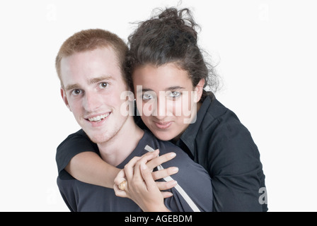 Porträt einer jungen Frau, die einen jungen Mann von hinten umarmen Stockfoto