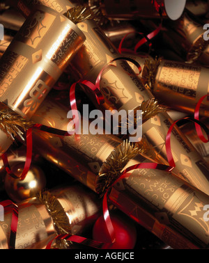 Ein Haufen goldener Weihnachtskräcker mit roten Bändern. Stockfoto