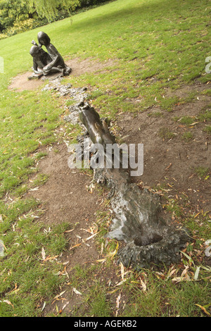 Statue von Alice beobachtete die Kaninchen in seine Höhle laufen Stockfoto