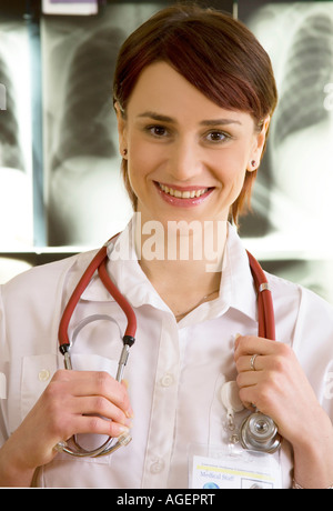 Lächelnde Krankenschwester mit Röntgenstrahlen im Hintergrund. Stockfoto