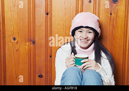 Junge Frau lächelnd hält Getränke Stockfoto