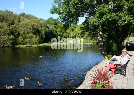 zwei Männer entspannend am Ufer des Flusses Cong, County Mayo, Irland Stockfoto