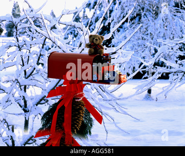 Weihnachten Postfach mit weihnachtliche Dekorationen geschmückt inmitten einer winterlichen Szene tief verschneiten Büsche und Äste Stockfoto