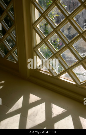 Fenster mit Schatten aus rautenförmigen Scheiben Stockfoto