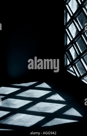 Fenster mit Schatten aus rautenförmigen Scheiben Stockfoto