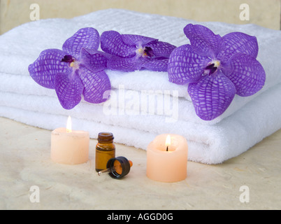 blaue Orchideen weiße Handtücher und Aromaöl Stockfoto