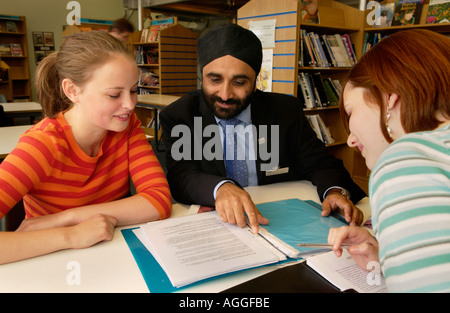 Sikh Lehrer mit Schülern der Oberstufe in Bibliothek des Colleges in Bristol England UK Stockfoto