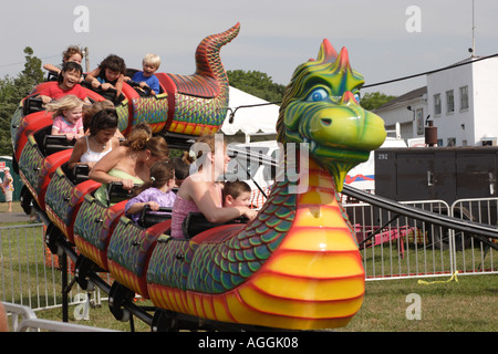 Kinder und Eltern auf Drachenbahn an Kirmes Stockfoto