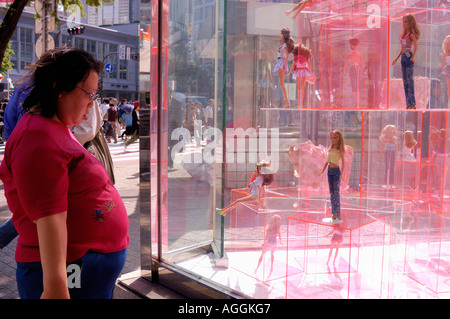 Fette Frau betrachten Puppen in Anzeige Fenster, Shibuya, Tokyo, Japan Stockfoto