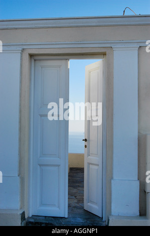 leicht geöffneter Tür mit blauem Himmel hinter Dorf Oia, Santorin, Griechenland Stockfoto