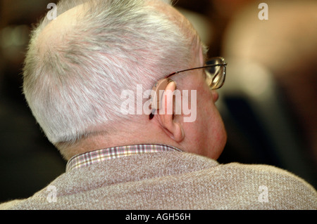 Ältere tauber Mann mit Hörbehinderung auf der Behinderung Hauptstadt Konferenz ein Hörgerät zu tragen Stockfoto