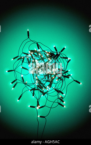 Bündel von Weihnachtsbaum-Lichterketten in ein Durcheinander auf grün blau Cyan Hintergrund Stockfoto