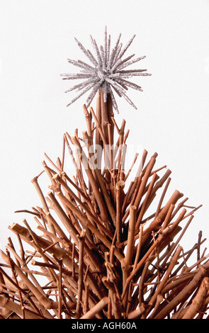 Aus Holz Weihnachtsbaum gemacht von Zweigen mit stacheligen Silberschmuck an der Spitze vor weißem Hintergrund Stockfoto
