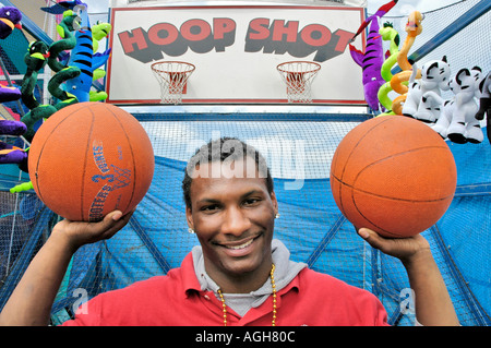Porträt von einem College African American Basketball Spieler arbeiten in Teilzeit auf einem Jahrmarkt, Schulgeld zu verdienen Stockfoto