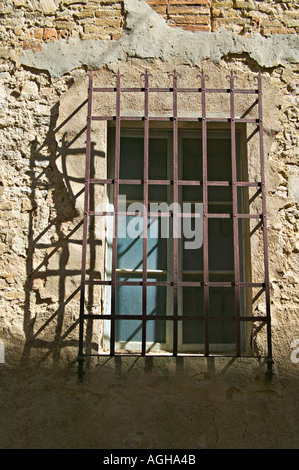 Vergittertes Fenster des Hauses auf die Via San Piero, San Gimignano, Toskana, Italien Stockfoto