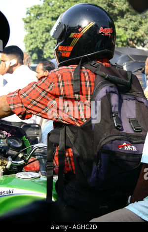 RSC91100 Mann auf dem Motorrad Helm mit einer Tasche auf dem Rücken in belebten überfüllten Ahmedabad Straße Gujarat Indien Stockfoto