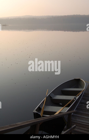 Einem festgemachten Schiff auf ein Mühlteich eines Sees bei Sonnenaufgang. Stockfoto