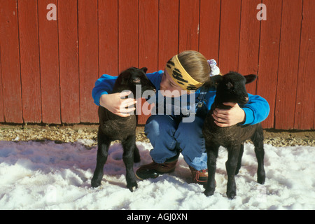 Mädchen auf Bauernhof mit jungen Haustier Lämmer Stockfoto