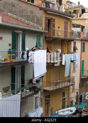 Frau hängen sauberen Wäsche von der Wäscheleine auf Balkon in die Cinque Terre Dorf Manarola Italien Stockfoto