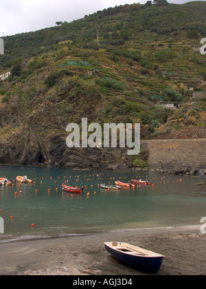 Ruderboot am Sandstrand mit terrassierten Hügeln der Stadt Vernazza Cinque Terre Italien im Hintergrund Stockfoto