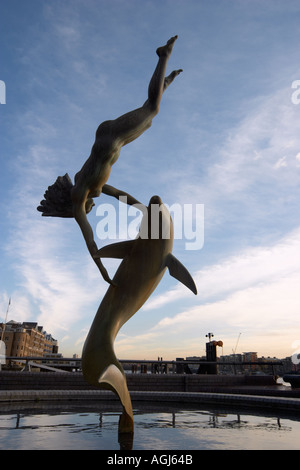 Mädchen mit einer Delfin-Statue von David Wynne in der Nähe von Tower Bridge London England Stockfoto